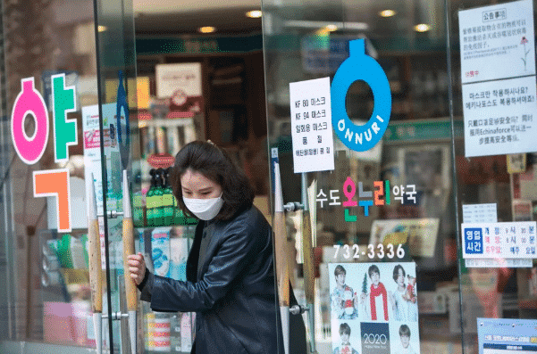 Một người phụ nữ đeo khẩu trang mua sắm ở Seol, Hàn Quốc. Ảnh: Bloomberg.